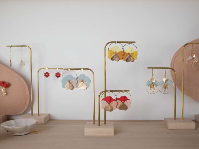 Les modèles de la collection déclinés à vos couleurs — boucles d'oreilles en cuir et dorure à chaud, personnalisables sur demande Collection de boucles d'oreilles en cuir surcyclé et dorure à chaud — pensées, fleurs et corolles déclinées en plusieurs coloris sur présentoirs laiton — Du vent dans mes valises, artisanat d'art