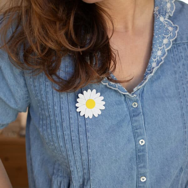 Broche marguerite en cuir blanc et jaune portée sur une robe en denim — bijou poétique fait main, artisanat d'art Du Vent dans mes Valises
