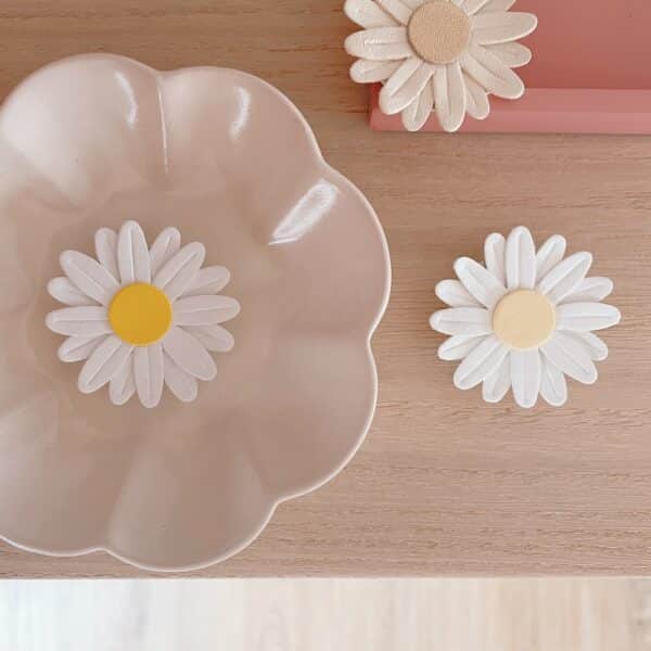 Trois broches marguerites : écru doré, ivoire jaune poudré et ivoire jaune d’or