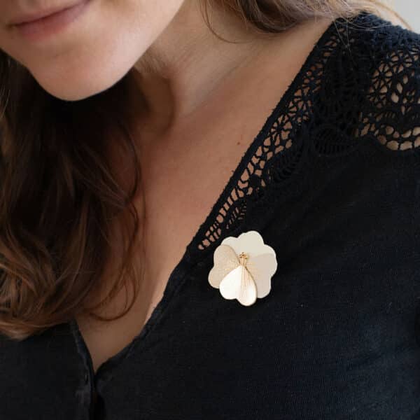 Broche pensée bucolique en cuir crème avec pétale doré portée sur un haut noir à dentelle — bijou artisanal fait main Du Vent dans mes Valises