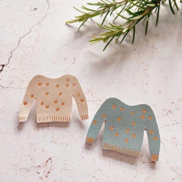 Broches en cuir en forme de pull miniature décoré de flocons, avec dorure à chaud.