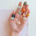 Pin’s Fleur de Bohème en cuir surcyclé, brodé à la main et orné d’une perle de laiton doré, bijou floral léger et élégant.