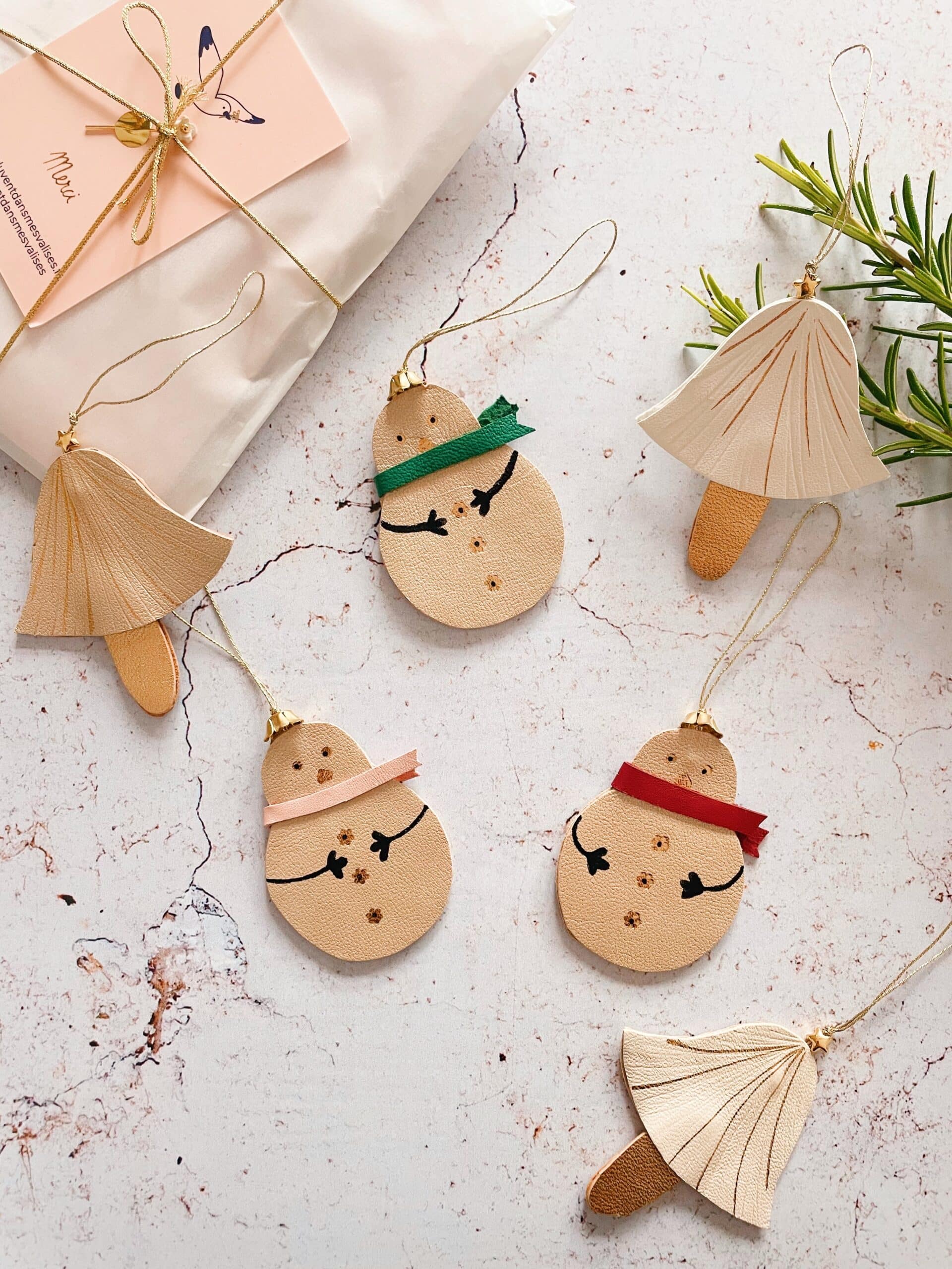 Décorations de Noël en cuir surcyclé, champignons et bonhommes de neige avec dorures artisanales.