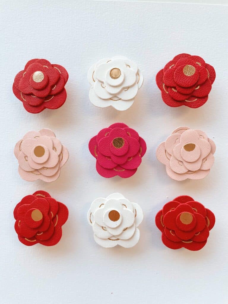 Broche artisanale en cuir surcyclé, rose façonnée à la main avec dorure à chaud, disponible en rouge carmin, rose fuchsia, rose pâle et blanc.