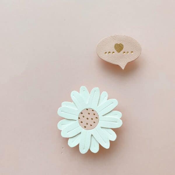 Pin’s Les Mots Doux en cuir surcyclé, forme rappelant une bulle de BD, inscription dorée à chaud, disponibles en bleu marine, ivoire, rose poudré et rouge. Personnalisation possible