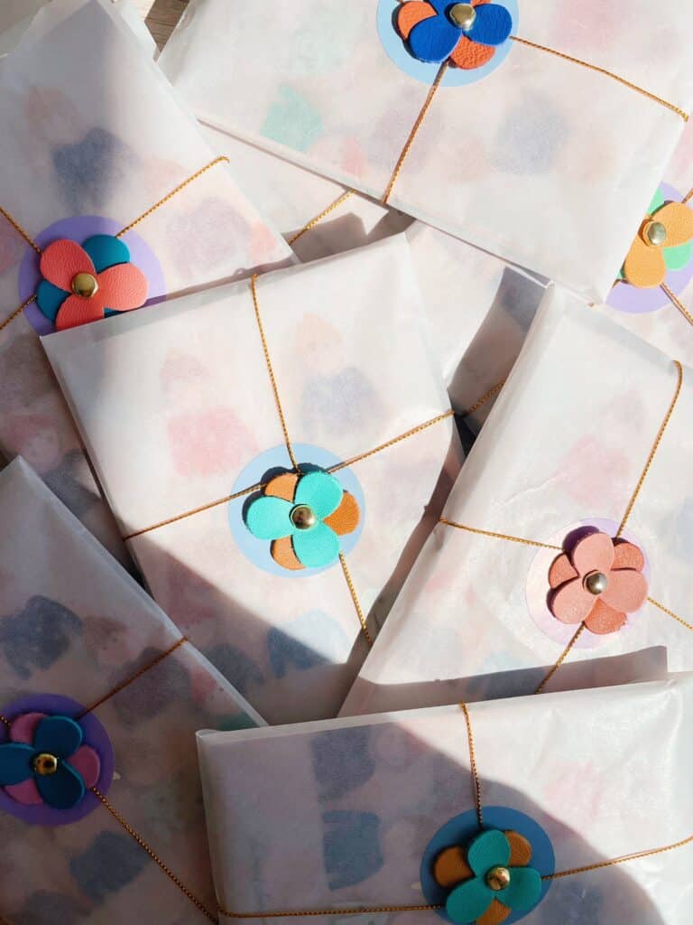 Pochette surprise artisanale contenant une broche fleurie, un pin’s et des trésors poétiques Titre