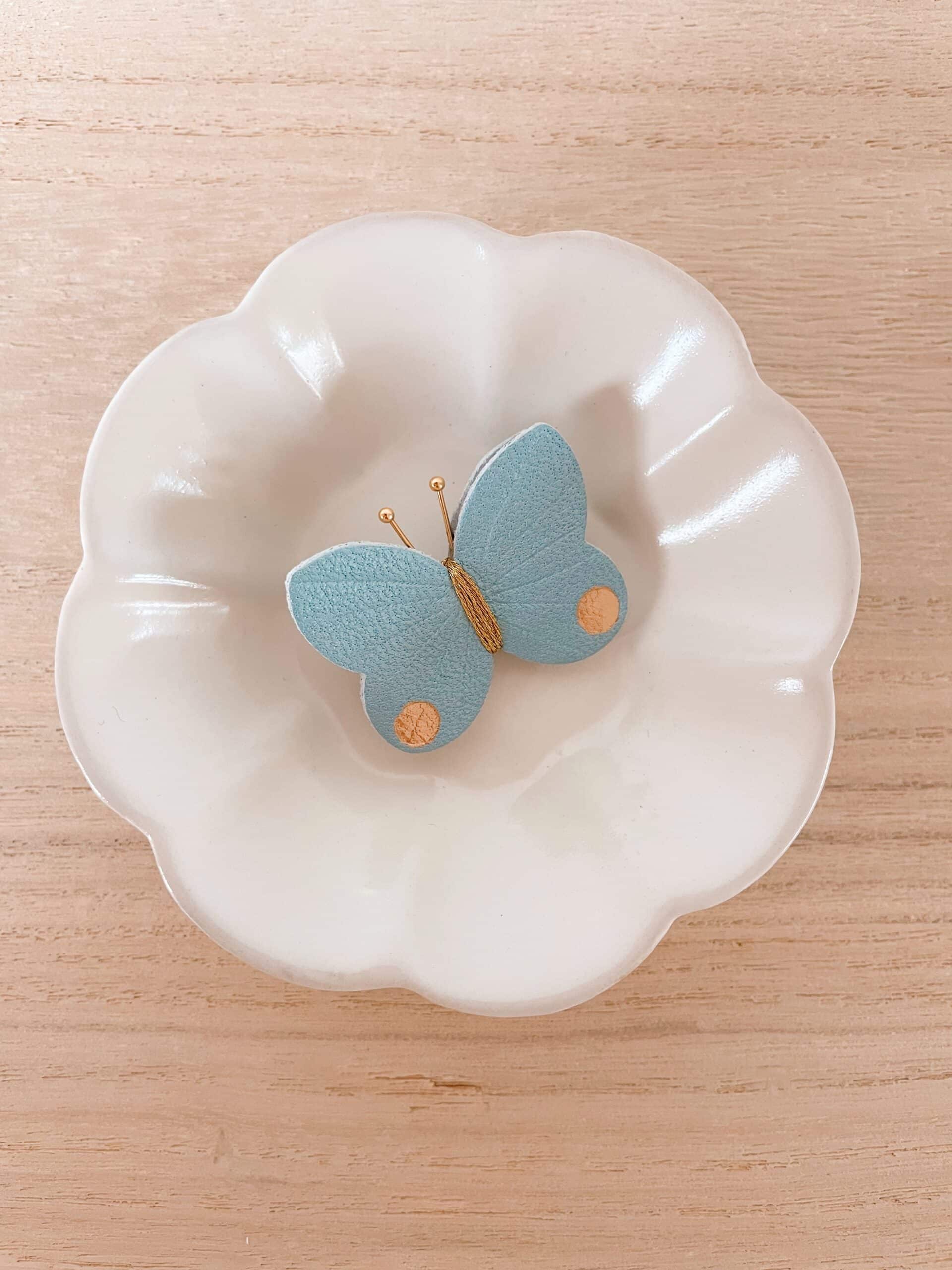 Broche Papillon bleu ciel irisé © Du vent dans mes valises Broche papillon bleu ciel irisé en cuir surcyclé, détails dorés, pièce unique fait main
