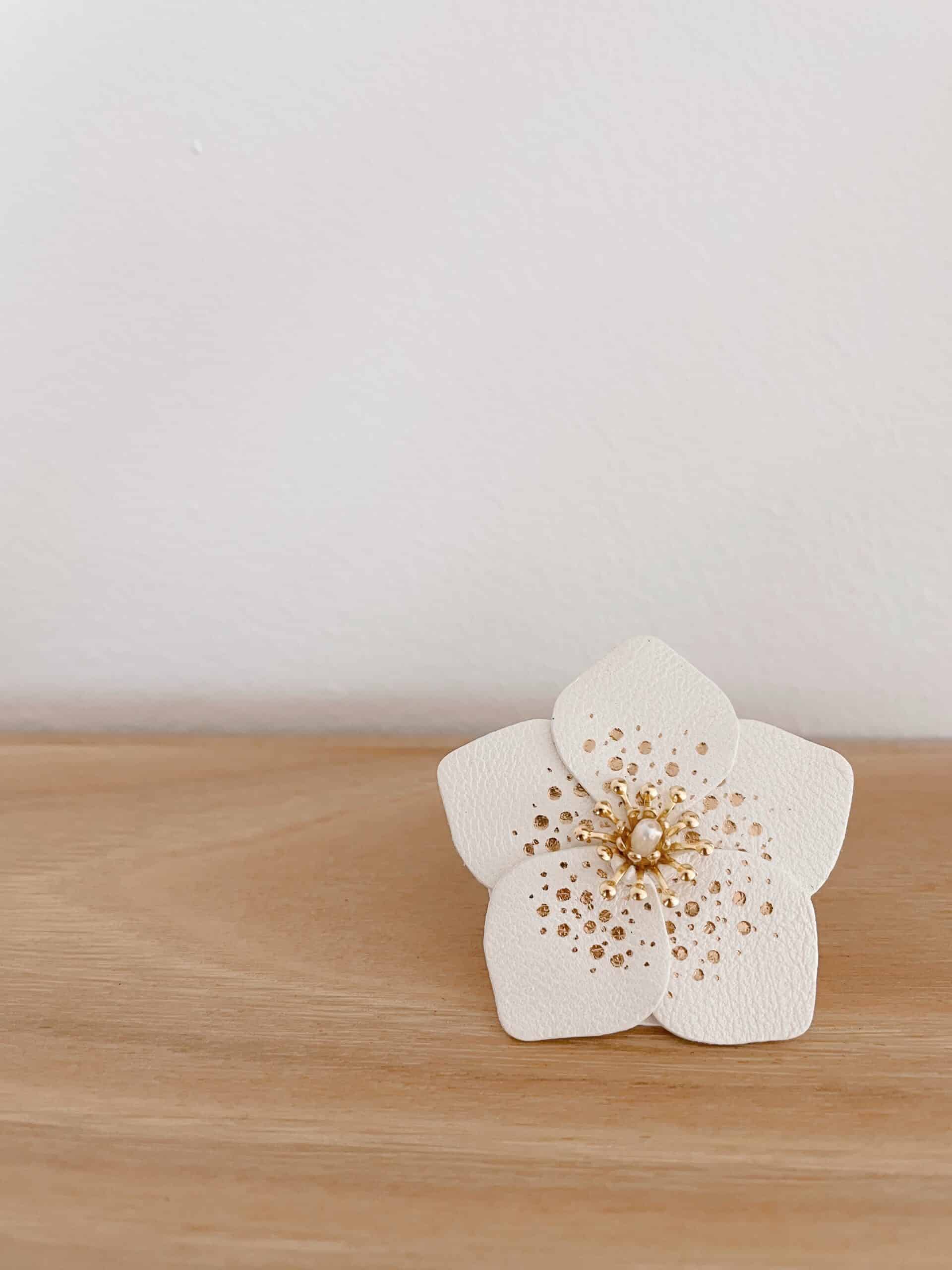 Broche Hellébore – rose de Noël blanche en cuir surcyclé et dorure à chaud © Du vent dans mes valise Broche rose de Noël en cuir façonnée à la main, modèle Hellébore – création artisanale