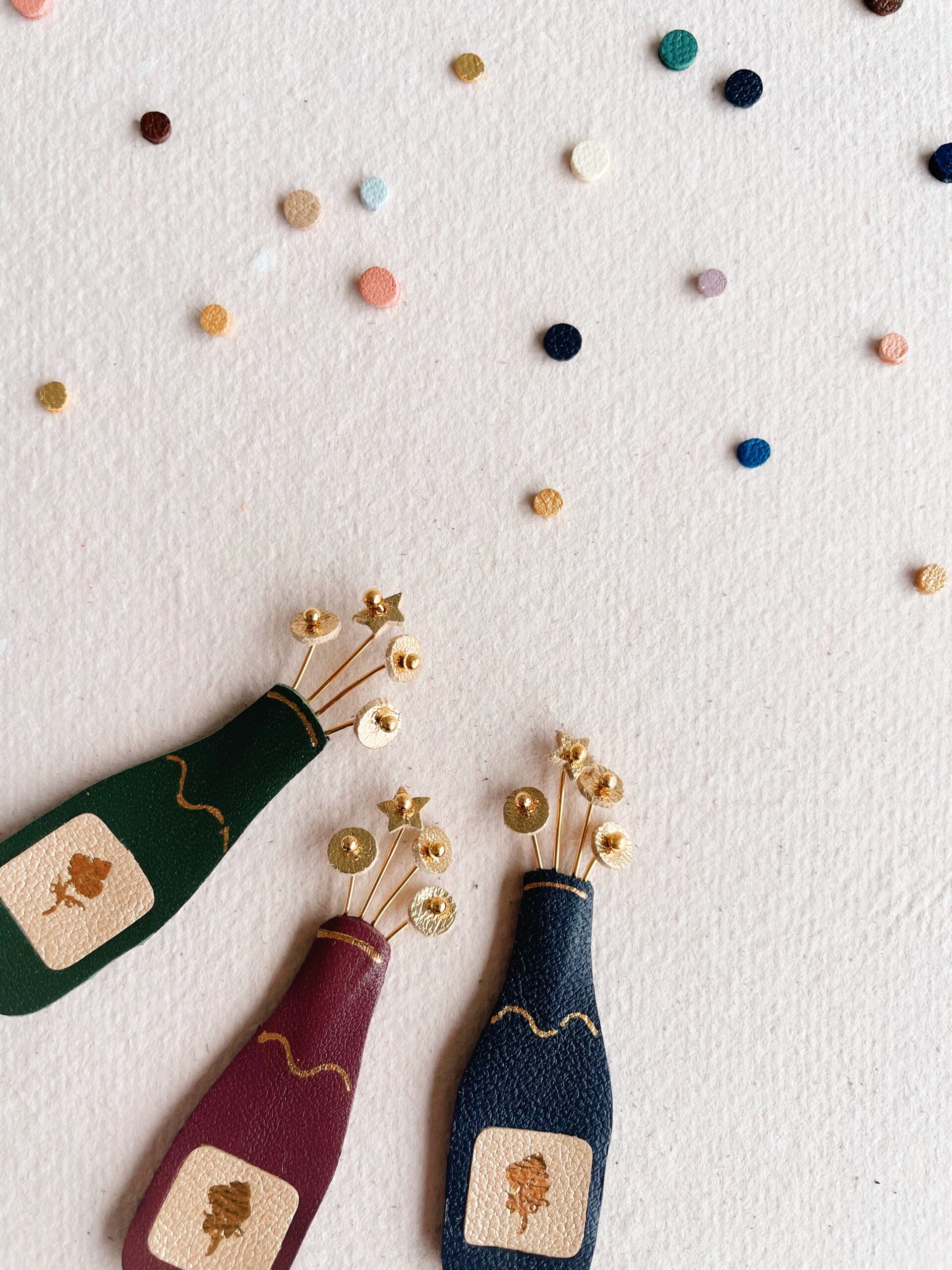 Broche pétillante façon bouteille de champagne artisanale – © Du vent dans mes valises 2 Broche bouteille de champagne artisanale en cuir avec bulles dorées