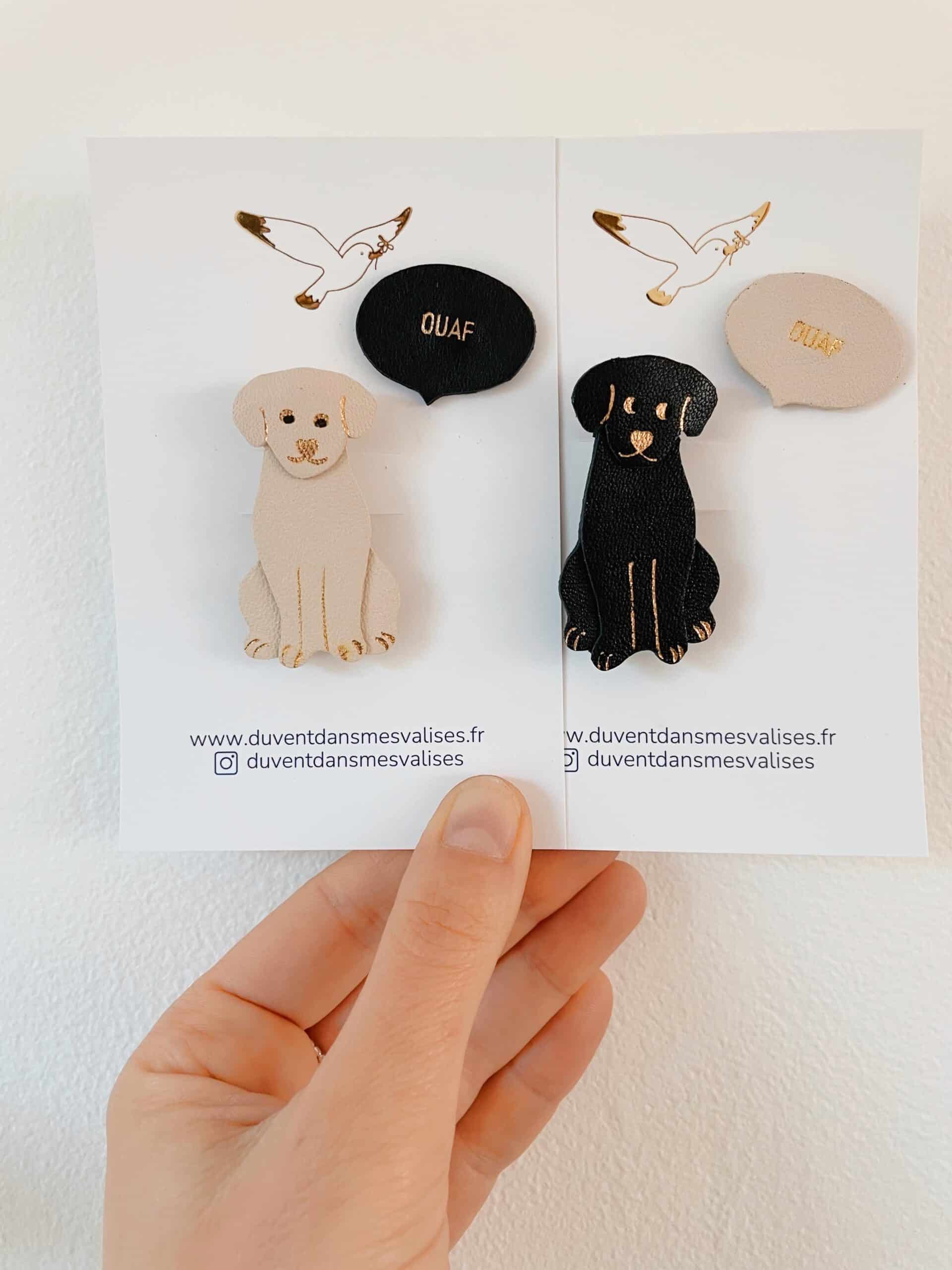 Duo de broches Labrad’or et pin's Ouaf – chien en cuir surcylcé et dorure artisanale © Du vent dans mes valises Duo de broche chien beige ou noire avec son pin's Ouaf en lettres dorées or fin, fabrication artisanale française en cuir surcyclé et dorure à chaud.