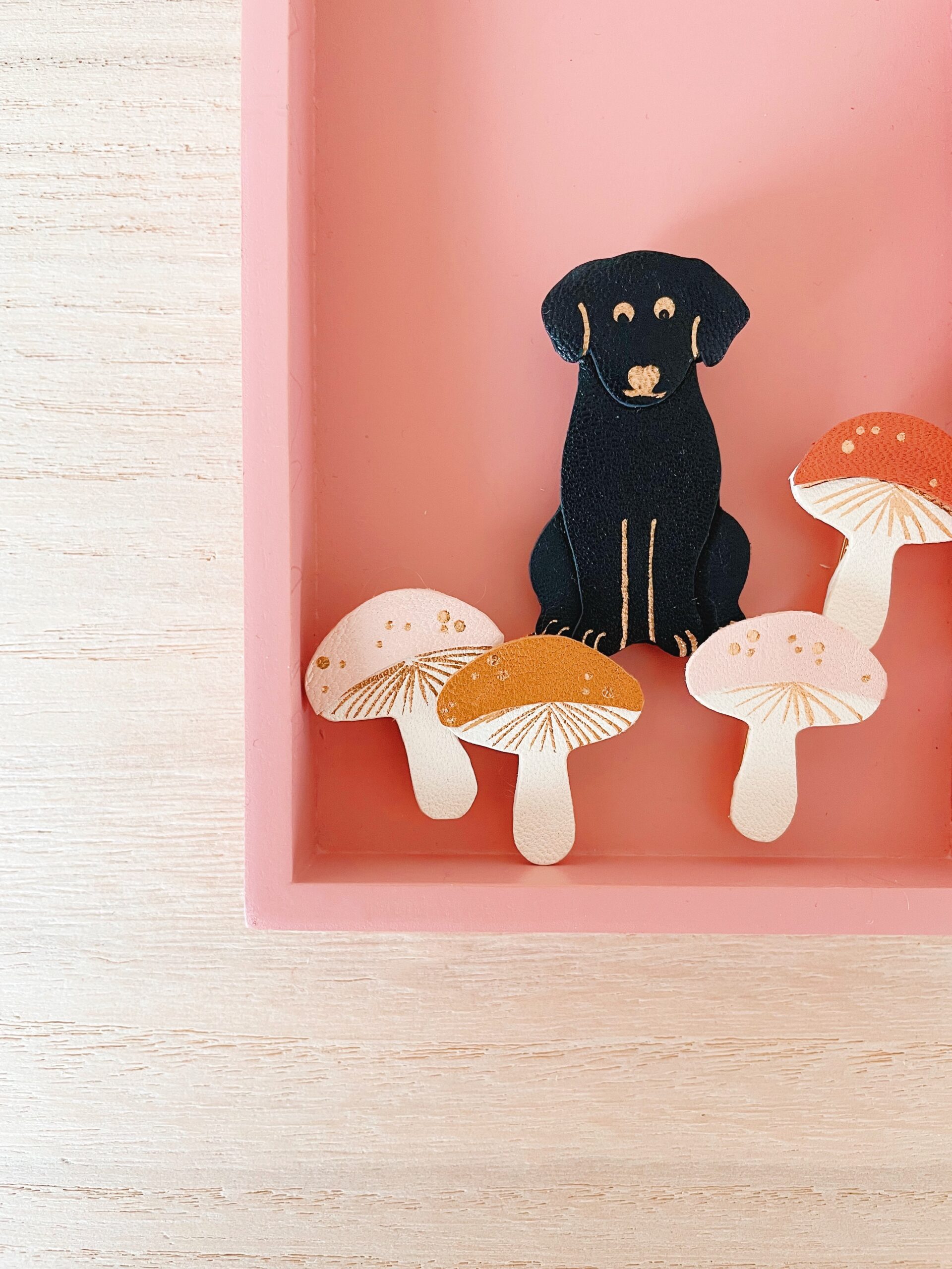 Broches champignons et Labrad’or – chien en cuir noir et dorure artisanale © Du vent dans mes valises Broches chien noir et champignons en cuir façonnée à la main avec détails en dorure à chaud – modèle Labrad’or