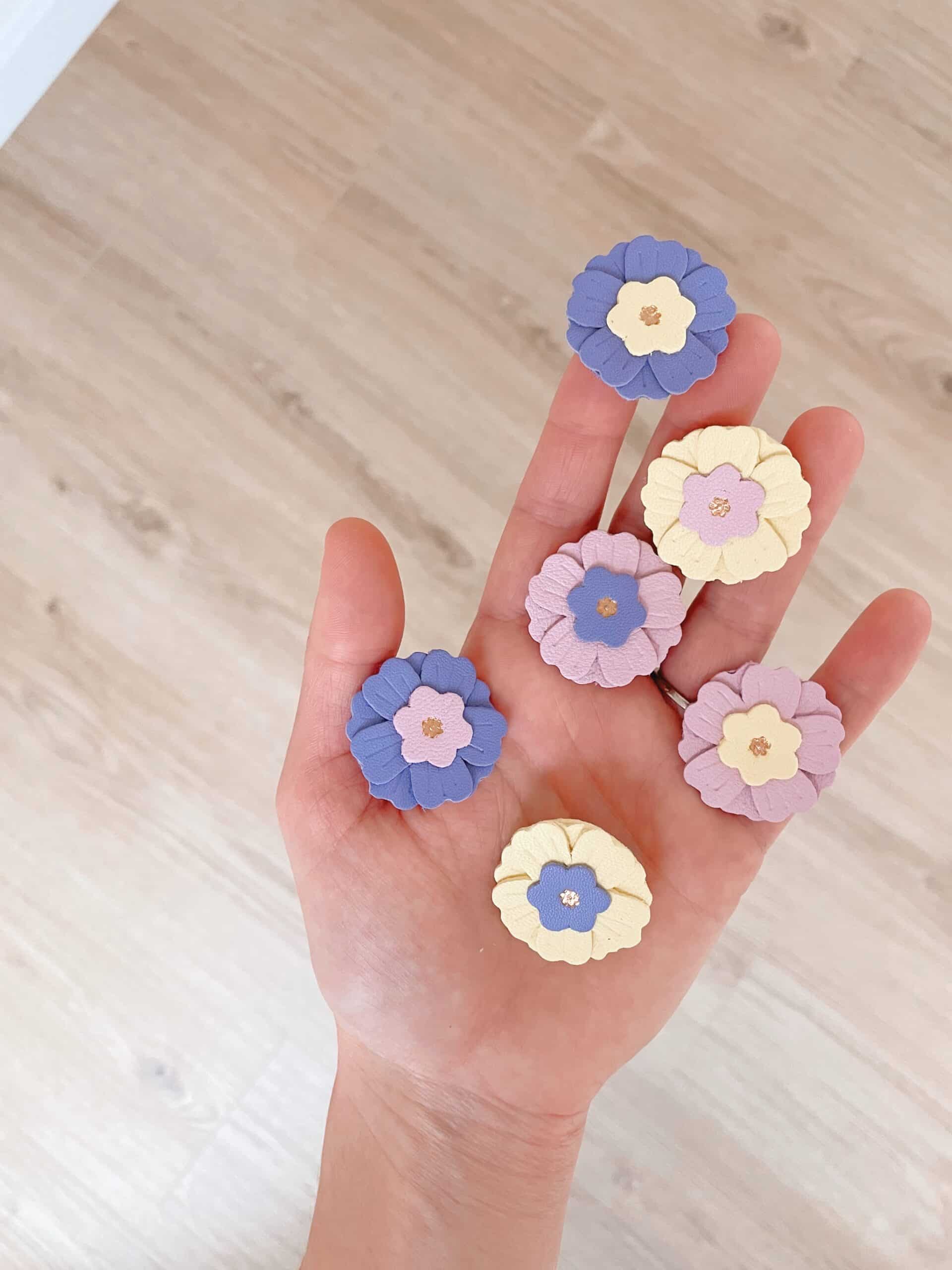 Broche Primevère – échelle en main © Du vent dans mes valises Broche Primevère env. 3 cm, taille portée en main, cuir surcyclé doré