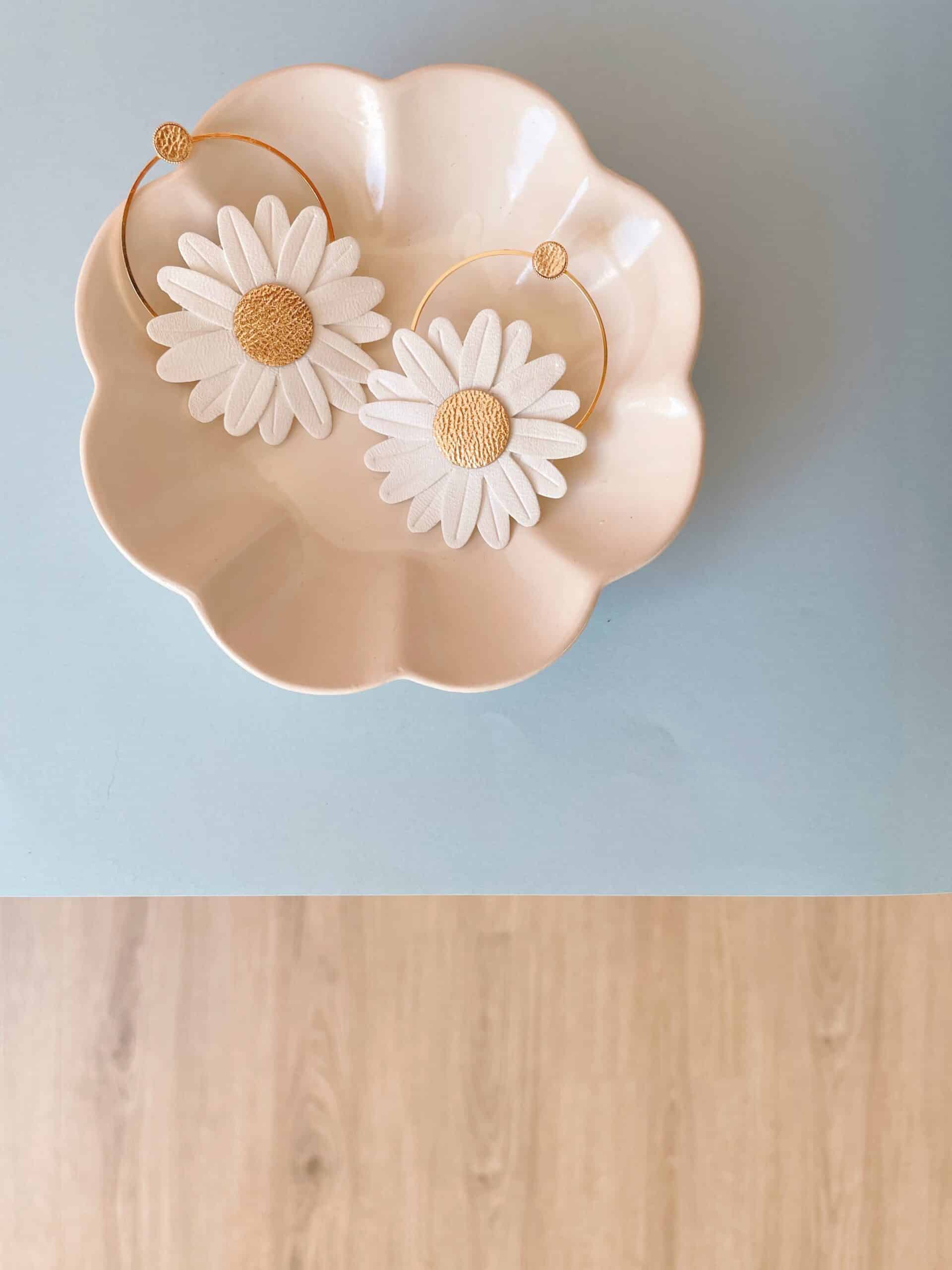 Créoles Marguerite blanches cœur doré © Du vent dans mes valises Créoles Marguerite blanches cœur doré, présentées dans une coupelle rose