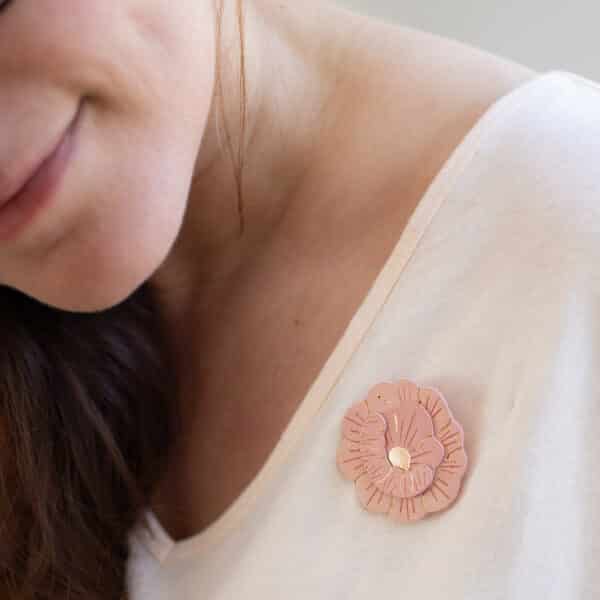 Broche pivoine en cuir upcyclé avec centre doré portée sur un t-shirt crème — bijou floral fait main Du Vent dans mes Valises
