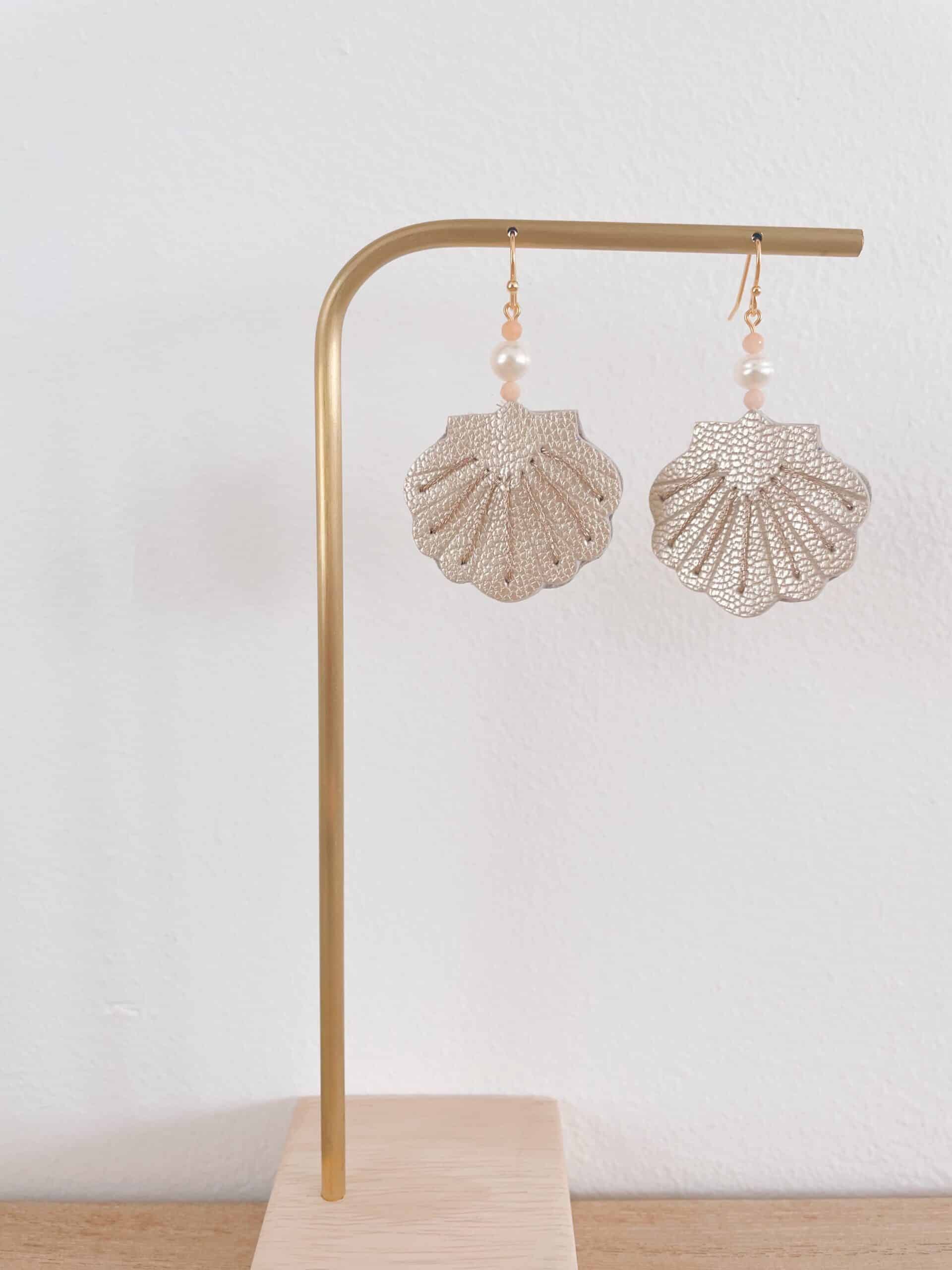 Boucles d'oreilles coquille Saint-Jacques en cuir surcyclé nacré, brodées main, perle d'eau douce et quartz roses, sur présentoir doré