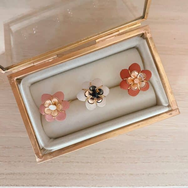 Bagues fleurs de bohème en cuir surcyclé présentées dans un écrin doré, coloris rose ancien, ivoire et terracotta