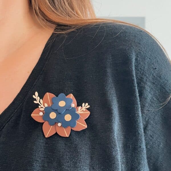 Broche buisson fleuri en cuir surcyclé portée sur pull noir, coloris chocolat et bleu nuit