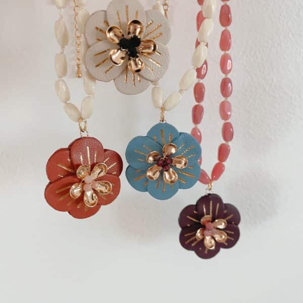 Quatre colliers Lison suspendus, perles anciennes de Briare et pendentifs fleurs en cuir