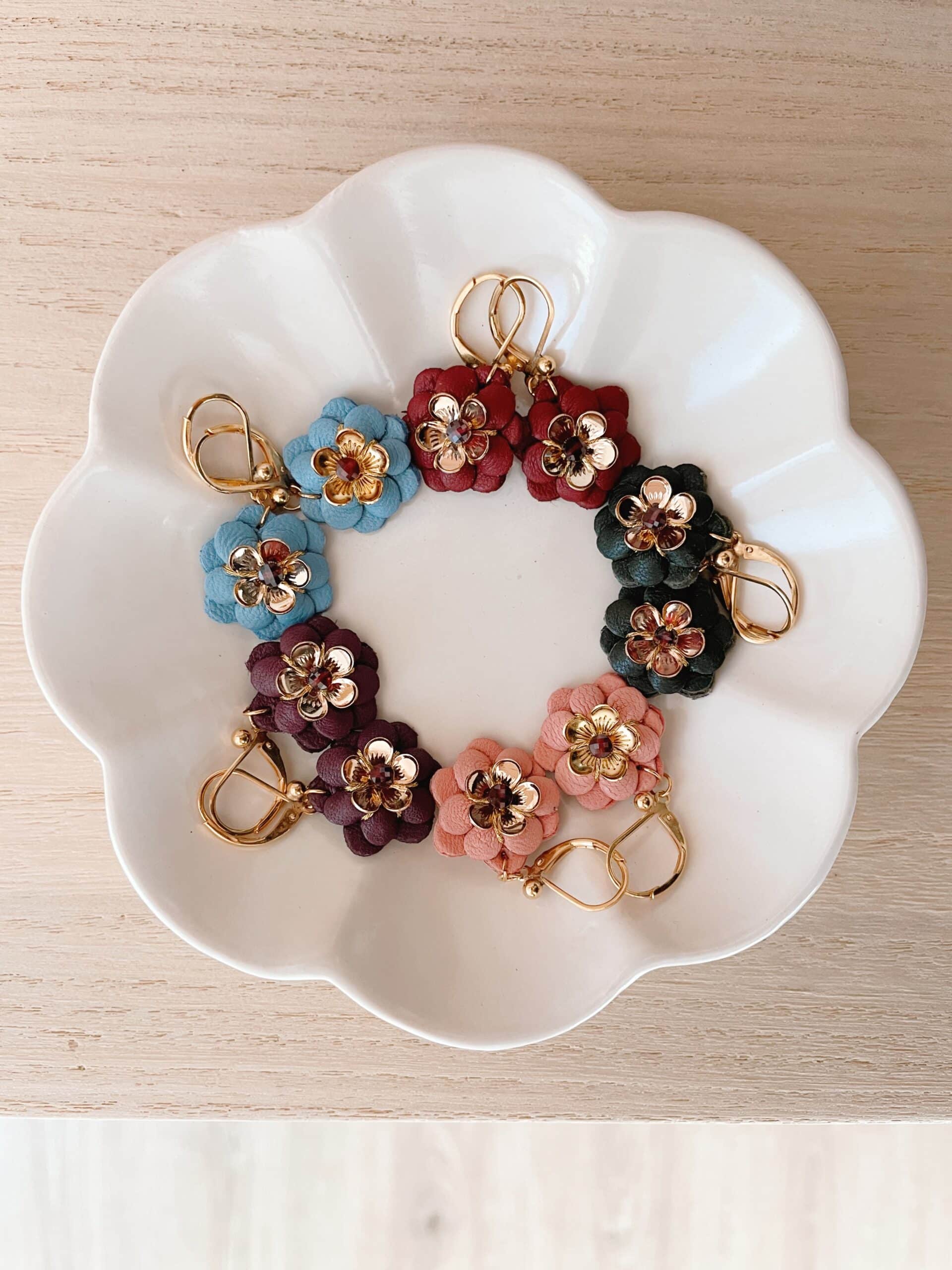 Boucles d’oreilles fleurs en cuir bleu gris, bordeaux, forêt, rose ancien et raisin, cœur doré et pierre fine grenat, dans une coupelle